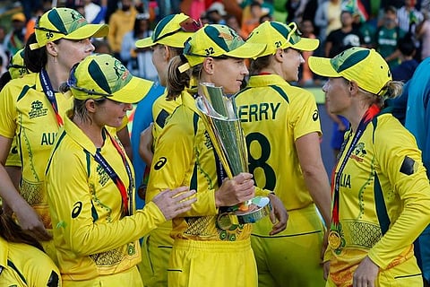 Australian players pose with T20 World Cup trophy after winning the World Cup final against South Africa. (Photo | AFP)