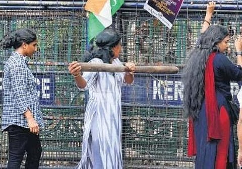 ​  A Mahila Congress worker trying to push a police barricade with a pestle during the protest march in front of the Secretariat against the anti-people policies of the state government on Friday | B