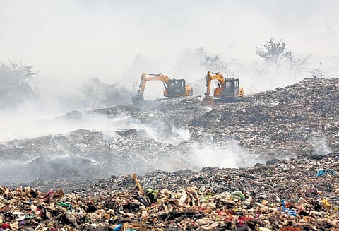 Smoke billows from the waste dumped at Brahmapuram | file pic