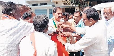 Former BJP minister Sogadu Shivanna has hit the streets of Tumakuru carrying two cloth bags hanging from his shoulders | Express