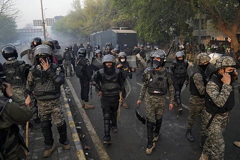 Paramilitary troops take position as riot police officer fire tear gas to disperse the supporters of former Prime Minister Imran Khan during clashes, in Lahore, on Mar 15, 2023. (Photo | AP)