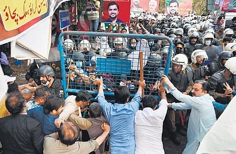 Imran Khan’s supporters clash with riot police in Lahore on Tuesday. (Photo | AFP)