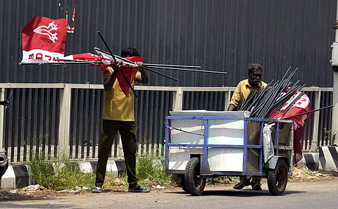 Unmindful of a BDJS meet at Kochi town hall, corporation workers remove the party's flags installed near Lissy junction in Kochi. (Photo | A Sanesh, EPS)