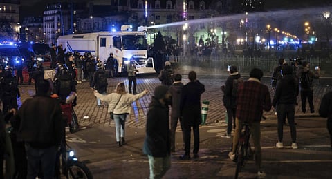A water canon sprays protesters during a demonstration in Paris. (Photo | AP)