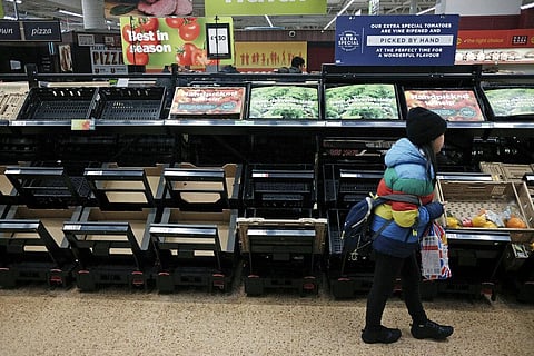 A girl walks by empty fruit and vegetable shelves at an Asda in east London (Photo | AP)