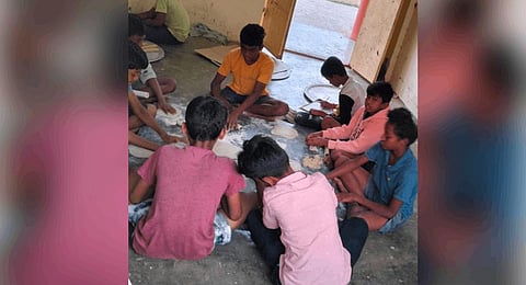 The students of tribal welfare hostel cooking meeals in kitchen due to shortfall of lower grade servants in Srikakulam district on Wednesday | express