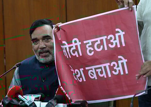 Delhi Minister Gopal Rai shows a poster that reads 'Modi Hatao, Desh Bachao' during a press conference, at Delhi Legislative Assembly. (Photo | PTI)