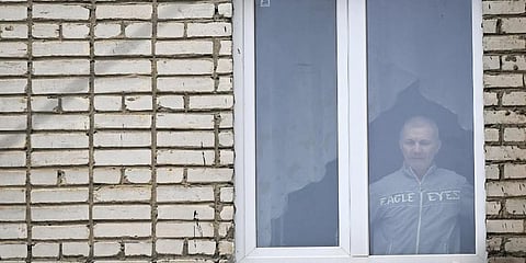 Alexei Moskalyov, father of Maria, look out through the window. (Photo | AFP)