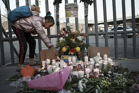 A girl lights candle during a vigil for the victims of a fire at an immigration detention center that killed dozens in Ciudad Juarez, Mexico, Tuesday, March 28, 2023. (Photo | AP)