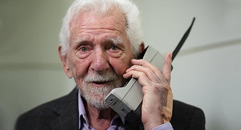 Marty Cooper, the inventor of first commercial mobile phone, poses for the press with a Motorola DynaTAC 8000x, during an interview with The Associated Press at the Mobile World Congress 2023. | AP