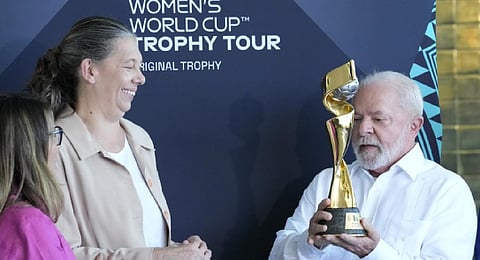 Brazilian President Lula da Silva holds the FIFA Women's World Cup Trophy as Minister of Sports Ana Moser looks on during the trophy's tour. (Photo | AP)