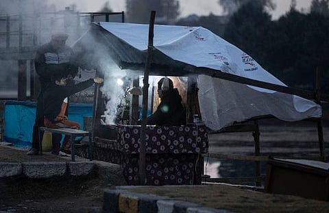 A Kashmiri vendor prepares traditional barbeque mutton for customers on the bank of the Dal Lake on a cold evening in Srinagar. (File Photo | AP)