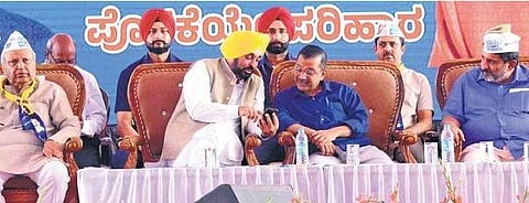 Punjab CM Bhagwant Mann shows something on his phone to his Delhi counterpart Arvind Kejriwal during a convention in Davanagere on Saturday | Express