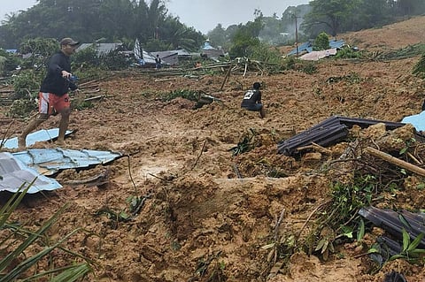 People inspect the site where a landslide hit a village on Serasan Island, Natuna regency, Indonesia, on Monday, March 6, 2023. (Photo | AP)