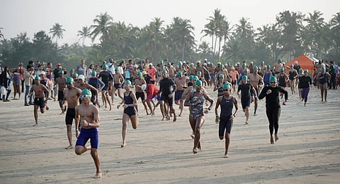 Swimmers rushing to the sea for a race at the Goa Swimathon