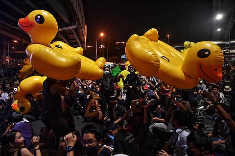 Protesters hold up large inflatable yellow ducks, which have become a symbol of the demonstrations, during an anti-government rally in Bangkok.  (Photo | AFP)