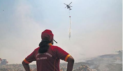 ​  A Navy helicopter continues aerial firefighting operation at Brahmapuram waste treatment plant in Kochi | T P Sooraj   ​