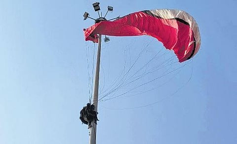 The paragliding instructor and a tourist who got trapped on a high mast light pole at Papanasam, Varkala in Thiruvananthapuram |Express  ​