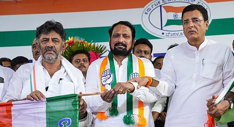 DK Shivakumar gives the party flag to former Karnataka deputy CM Laxman Savadi as the latter joins Congress ahead of Karnataka Assembly polls, at the KPCC office.(File Photo | PTI)