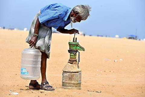A local shop vendor checks a broken water pump for groundwater in Marina Beach, Chennai as temperatures soar in Tamil Nadu touching 40 degrees Celsius. (Photo | P Ravikumar, EPS)