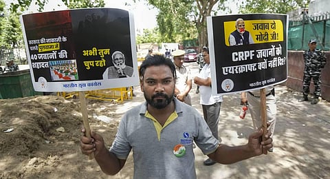 An Indian Youth Congress supporter holds placards during a protest over former J-K governor Satya Pal Malik's claims on Pulwama attack, in New Delhi, April 18, 2023. (Photo | PTI)