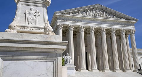 The Supreme Court is seen, with a carving of Justice in the foreground. (Photo | AP)