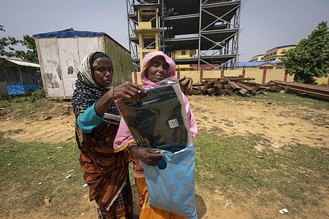 Asiya Khatoon (R), carrying a T-shirt, trousers and a cap for her husband Abul Kalam, cries as she walks towards his detention center in Assam's Matiya village, April 17, 2023. (Photo | AP)