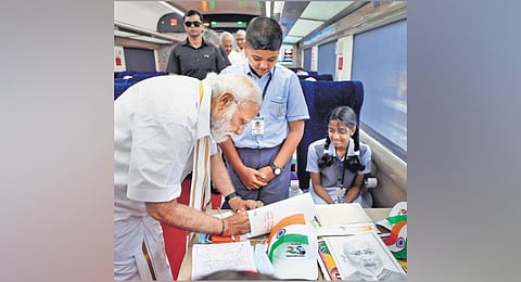 Prime Minister Narendra Modi signs paintings and essays by students, on board the  Vande Bharat Express at Thiruvananthapuram Central Station on Tuesday | PTI