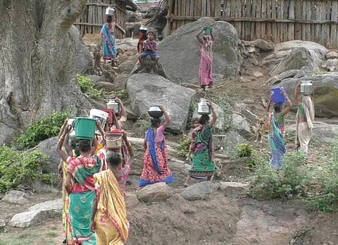 Womenfolk of Bhaliaguda returning to their village with water collected from the nearby stream | Express