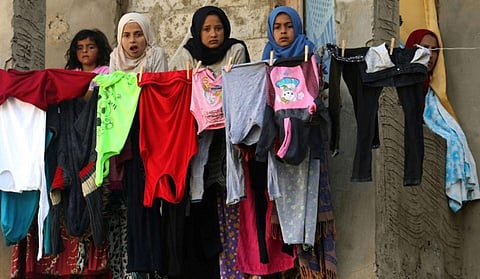 Syrian refugees stand ion the balcony of a building under construction which they have been using as shelter in the city of Sidon in southern Lebanon. (Photo | AP)