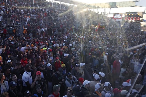 Fans flood onto the track after the finish of the Australian Formula One Grand Prix at Albert Park in Melbourne. (Photo | AP)