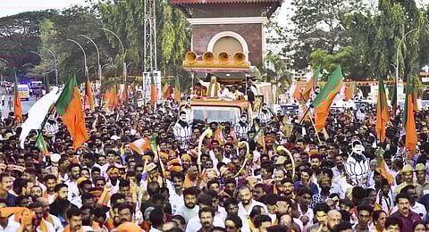 Amit Shah waves at supporters during a roadshow ahead of Assembly polls, in Mangaluru, Saturday, April 29. (Photo | PTI)
