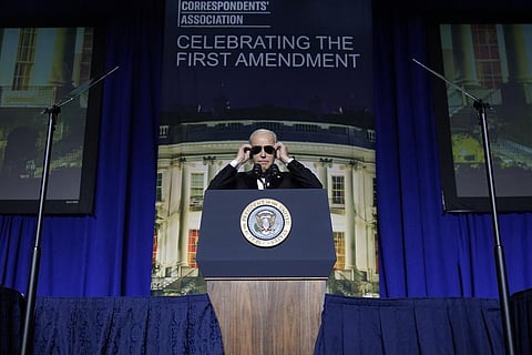 President Joe Biden puts on sunglasses after making a joke about becoming the 'Dark Brandon' persona during the White House Correspondents' Association dinner at the Washington Hilton. (Photo | AP)