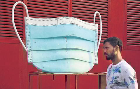 Representational Image: Amid daily count of Covid-19 cases on the rise, a man walks past the model of a mask, at Nandhanam metro station, Chennai | Ashwin Prasath