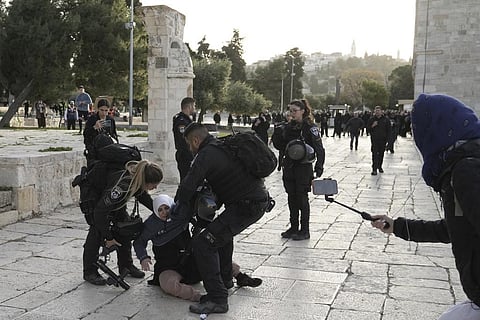 Israeli police arrest a Palestinian woman at the Al-Aqsa Mosque compound following a raid at the site in the Old City of Jerusalem during Ramadan, April 5, 2023. (Photo | AP)
