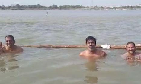 Screengrab from a video of the supporters of BJP MLA and ex-minister Harishankar Khatik taking a vow with their leader in the Saryu in Ayodhya. (Credits | Twitter)