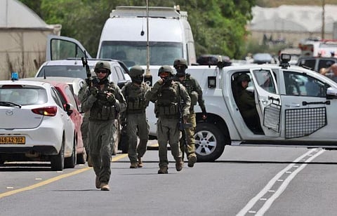 Israeli forces and emergency personnel gather near the Hamra junction, in the northern part of the Jordan valley in the occupied West Bank, following a shooting attack on April 7, 2023. (Photo | AFP)
