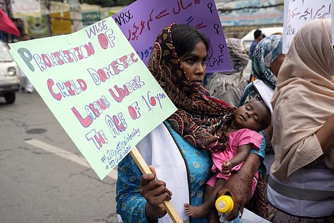 A Pakistani female worker holds her baby and joins a May Day rally, marking International Labour Day in Lahore, Pakistan, Monday, May 1, 2023. (Photo | AP)