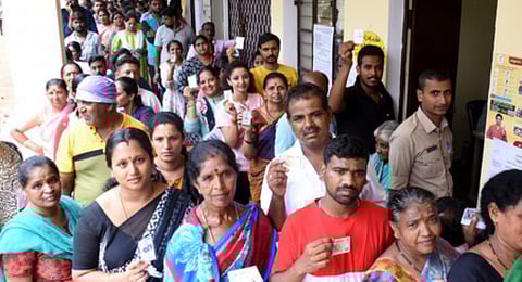 People standing in a long queue at polling booth in Mysuru on Wednesday.(Udayashankar S , EPS)