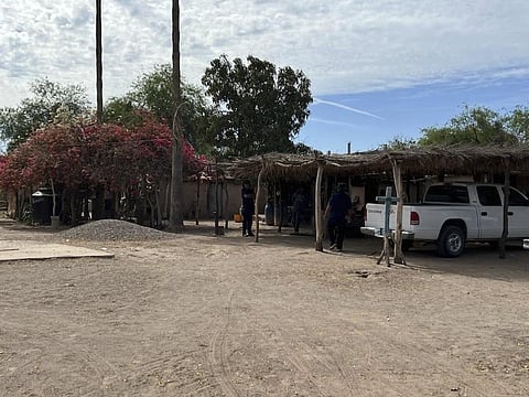 A cross stands at a home in Sonora, Mexico, is shown in 2022 while members of the Pascua Yaqui Tribe pick up cultural participants from their related tribal community. ( Photo | AFP )