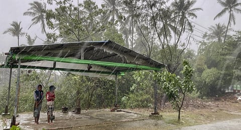 Two children stand under a roadside shelter to protect from rain before Cyclone Mocha hits in Sittwe, Rakhine State, Sunday, May 14, 2023.(Photo | AP)