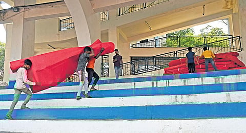 Workers get red carpets to be used on the day of swearing-in of the new CM at Sree Kanteeraeva Stadium on Wednesday. (Photo | Vinod kumar)