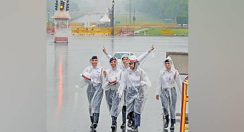 Traffic police personnel wearing raincoats during rain on Monday. (Photo | PTI)