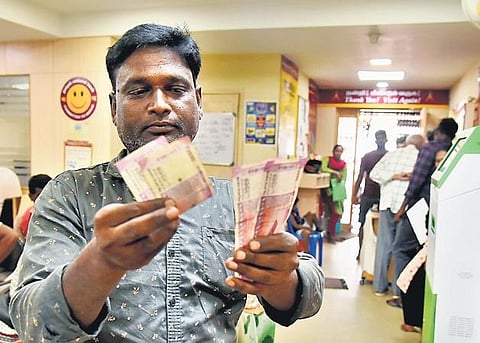A customer counts notes for exchange at a bank in Chennai. (Photo | P Ravikumar, EPS)