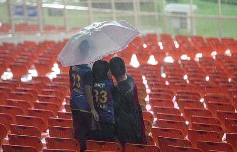 Cricket fans holding umbrellas wait as it rains heavily before the start of the IPL 2023 final cricket match between CSK and GT in Ahmedabad, Sunday, May 28, 2023. (Photo | PTI)