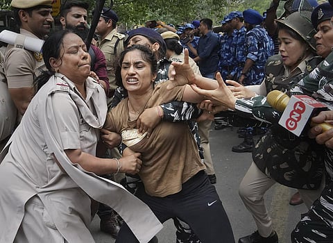 Security personnel detain wrestler Vinesh Phogat during wrestlers protest march towards the new Parliament building, in New Delhi, Sunday, May 28, 2023. (Photo | PTI)