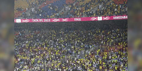 Spectators try to cover themselves as it rains ahead of the IPL 2023 final cricket match between GT and CSK. (Photo | PTI)