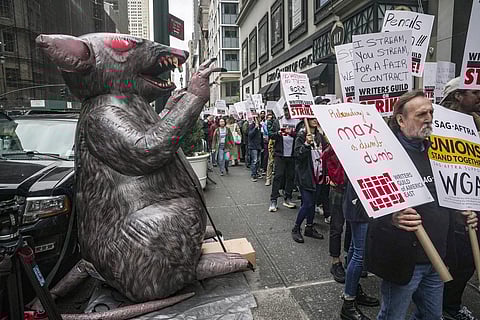An organized labor symbol of a giant inflatable rat (L), is displayed as members of the The Writers Guild of America picket outside Peacock NewFronts, Tuesday, May 2, 2023, in New York. (Photo | AP)