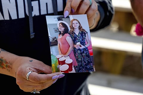 Ashleigh Webster shows a photo of Ivy Webster and Tiffany Guess at her home in Henryetta, Okla., Tuesday, May 2, 2023. (Photo | AP)
