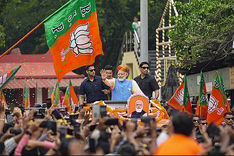 Prime Minister Narendra Modi waves at supporters during a road show ahead of Karnataka Assembly elections, in Bengaluru, Saturday, May 6, 2023. (Photo | PTI)
